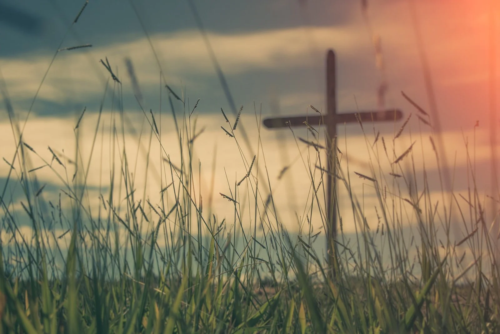 Cruz num campo ao pôr do sol